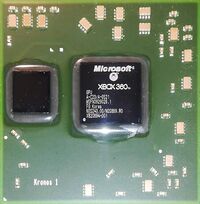 An image of a 65 nanometer graphics processing unit from a Microsoft Xbox 360. The die is in the center of the green square, and the eDRAM is located to the left of it. The die has a light, whitish underfill- indicating that it is not one of the defective units.
